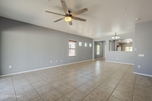 20868 E Treasure Rd, Red Rock, AZ 85145 - empty room featuring light tile patterned flooring, ceiling fan with notable chandelier, and baseboards