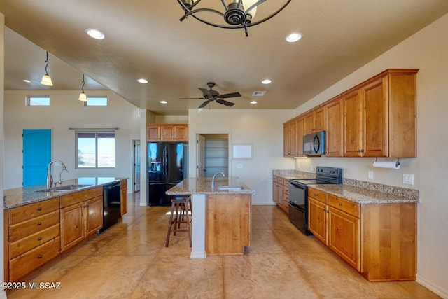 9505 S Deer Ridge Trl, Hereford, AZ 85615 - kitchen featuring recessed lighting, brown cabinetry, black appliances, a sink, and a center island with sink