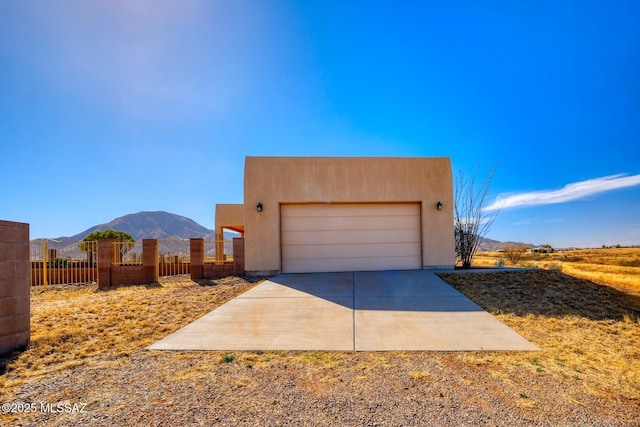 9505 S Deer Ridge Trl, Hereford, AZ 85615 - view of front of house featuring a mountain view, a garage, stucco siding, and fence