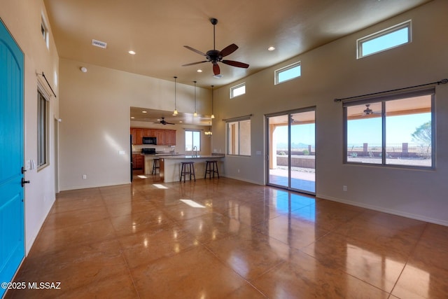 9505 S Deer Ridge Trl, Hereford, AZ 85615 - unfurnished living room with visible vents, recessed lighting, a ceiling fan, and a towering ceiling