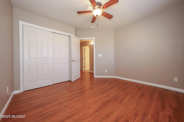 8418 N Sayante Way, Tucson, AZ 85743 - unfurnished bedroom with baseboards, wood finished floors, a closet, and a ceiling fan