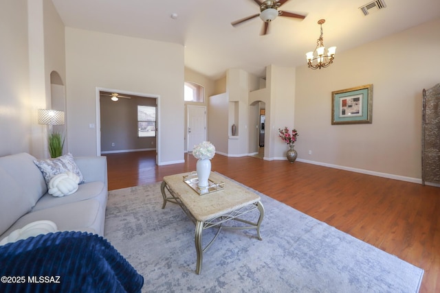 8418 N Sayante Way, Tucson, AZ 85743 - living area with lofted ceiling, ceiling fan with notable chandelier, arched walkways, visible vents, and wood finished floors