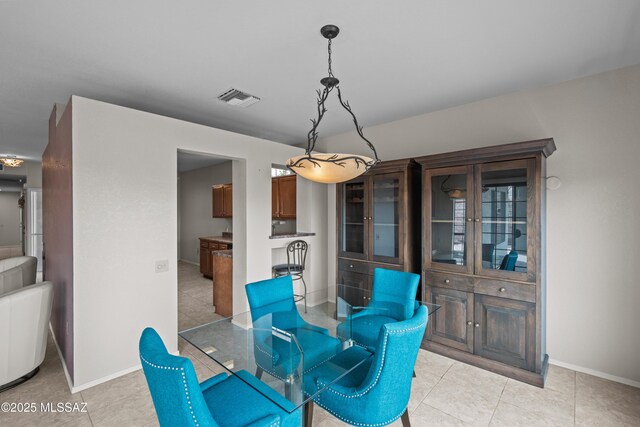 dining space featuring light tile patterned floors, baseboards, and visible vents