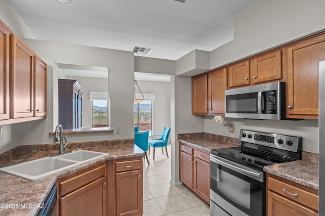 kitchen with a sink, visible vents, brown cabinets, and stainless steel appliances