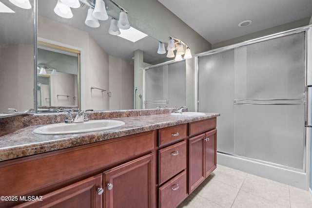 bathroom featuring a sink, a shower stall, tile patterned flooring, and double vanity