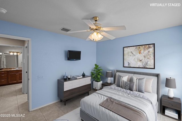 bedroom featuring ceiling fan, light tile patterned floors, visible vents, a sink, and baseboards