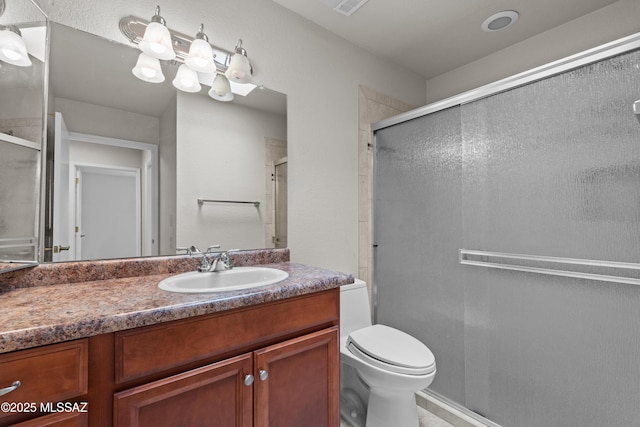 full bath featuring toilet, a stall shower, and vanity