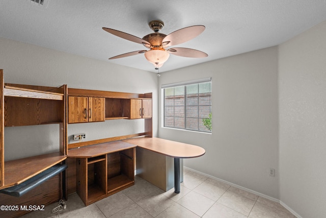unfurnished office featuring light tile patterned floors, baseboards, and ceiling fan