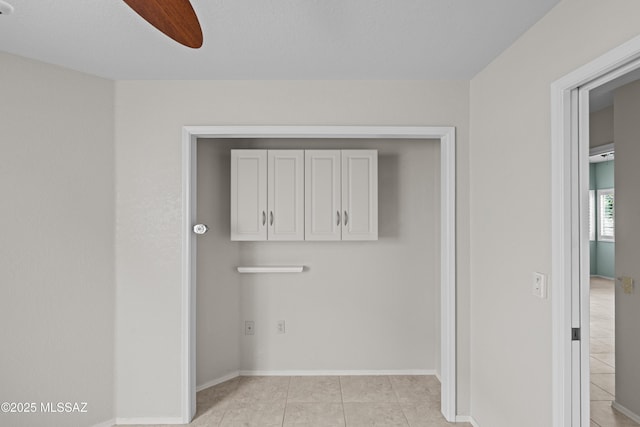 interior space with light tile patterned floors and ceiling fan