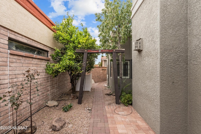 view of home's exterior with stucco siding and fence