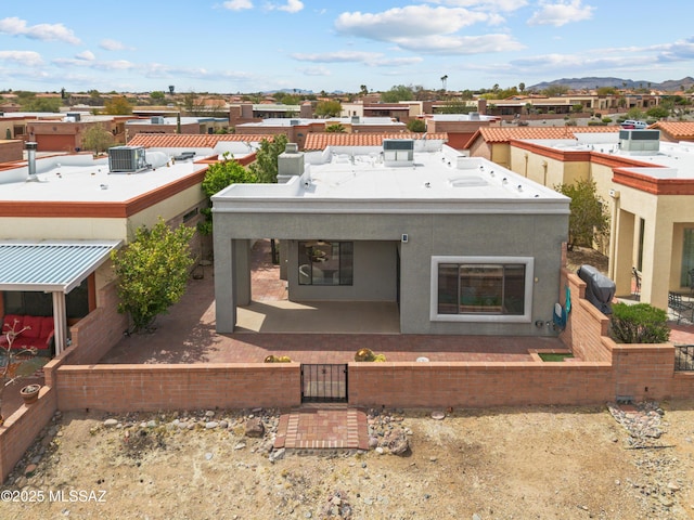 rear view of property with a fenced front yard and stucco siding