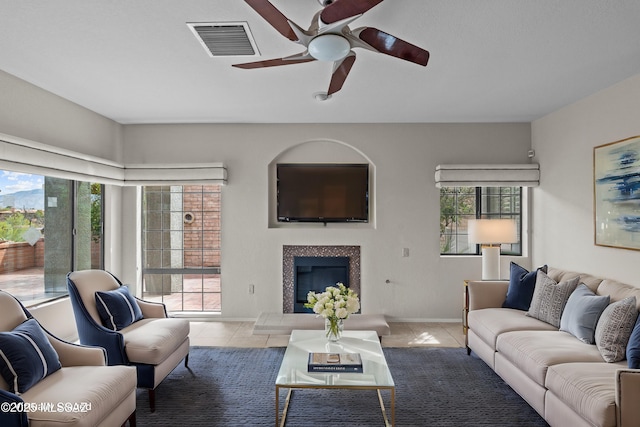 living area with a healthy amount of sunlight, tile patterned flooring, visible vents, and ceiling fan