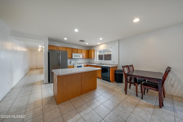 9379 E Grapevine Spring Pl, Tucson, AZ 85710 - kitchen featuring white appliances, a center island, light countertops, light tile patterned floors, and recessed lighting