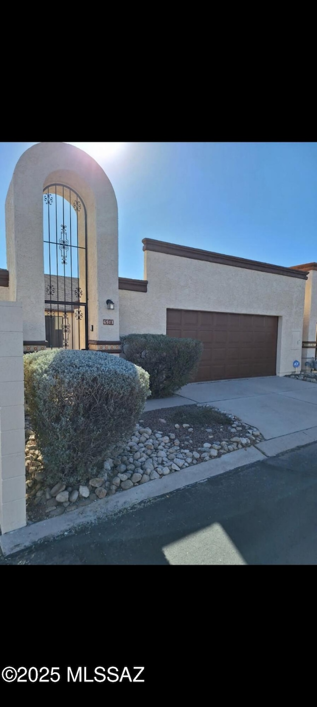 view of front of property featuring stucco siding, driveway, and a garage