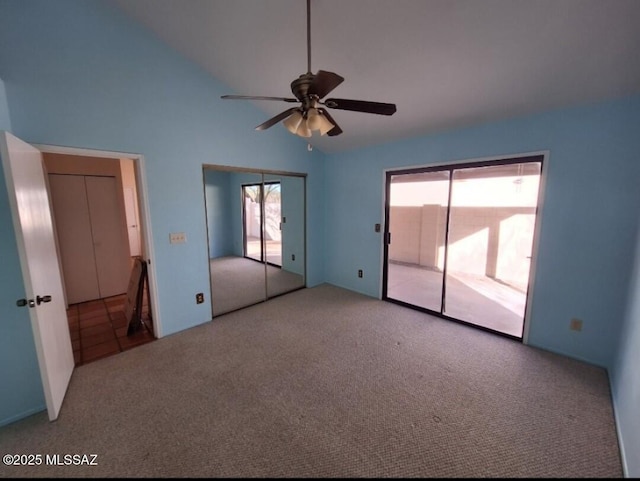 unfurnished bedroom featuring multiple windows, vaulted ceiling, carpet, and access to outside