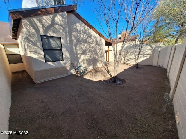 back of house featuring a fenced backyard, stucco siding, and a patio
