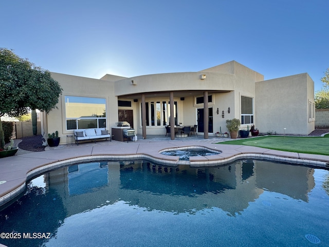 outdoor pool with an in ground hot tub and a patio area