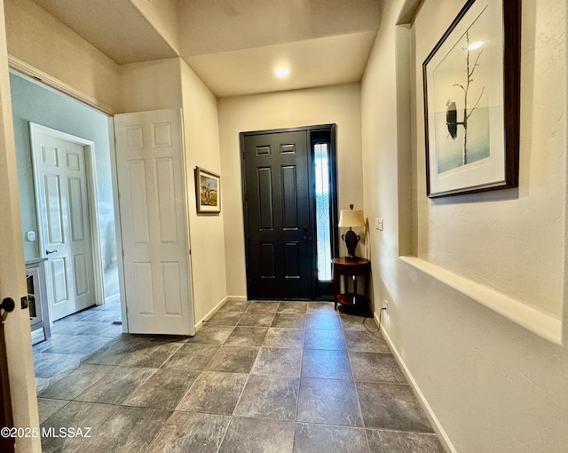 entryway featuring stone finish floor and baseboards