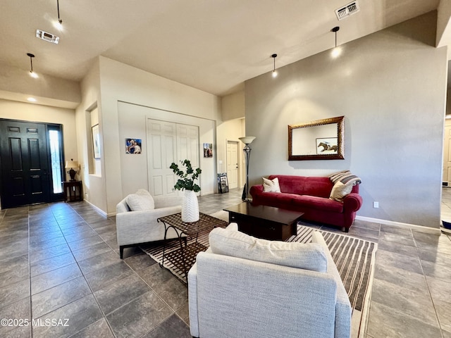 living area with baseboards and visible vents