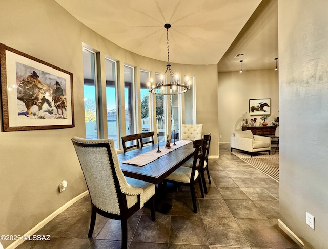 dining area featuring baseboards and a chandelier