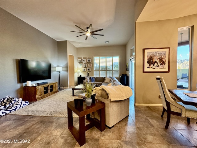 living area featuring baseboards, visible vents, and a ceiling fan