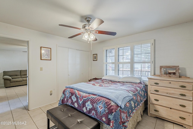 bedroom featuring light tile patterned floors, a closet, and ceiling fan