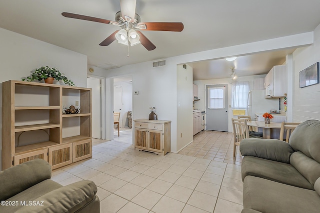 living area with light tile patterned floors, visible vents, and ceiling fan