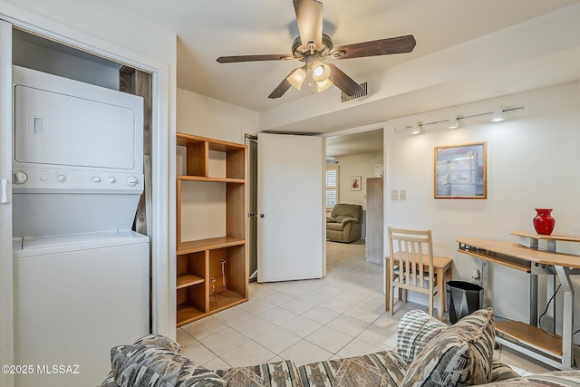 laundry room with visible vents, ceiling fan, stacked washer and dryer, light tile patterned floors, and laundry area