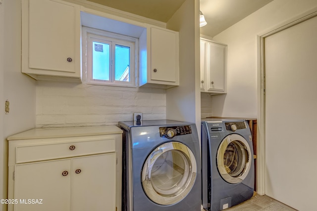 washroom featuring cabinet space and washing machine and dryer