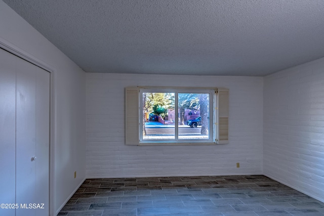 empty room featuring wood tiled floor and a textured ceiling