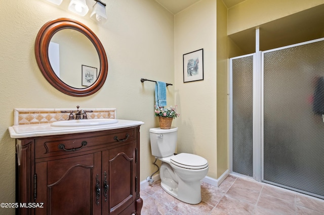 full bath featuring tile patterned flooring, baseboards, toilet, a stall shower, and vanity