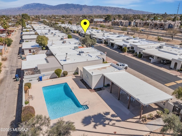 community pool with a mountain view, a residential view, and a patio