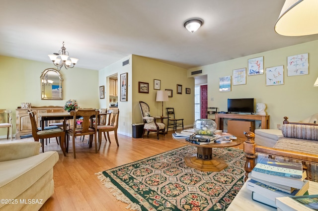 living room with a chandelier and light wood-type flooring