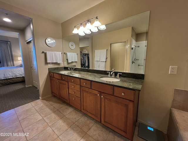 5775 S Camino Del Sol Unit 6104, Green Valley, AZ 85622 - ensuite bathroom featuring double vanity, tile patterned floors, baseboards, a shower, and a spacious closet