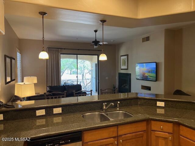 5775 S Camino Del Sol Unit 6104, Green Valley, AZ 85622 - kitchen featuring a sink, dishwashing machine, open floor plan, brown cabinetry, and ceiling fan