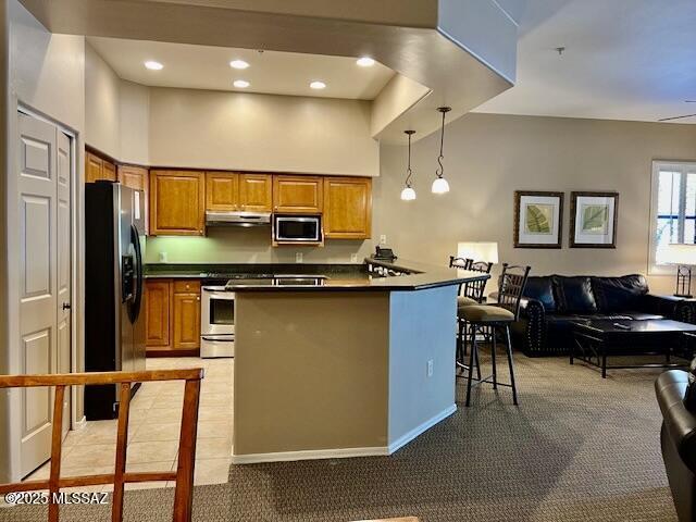 5775 S Camino Del Sol Unit 6104, Green Valley, AZ 85622 - kitchen featuring stainless steel appliances, dark countertops, open floor plan, brown cabinets, and recessed lighting