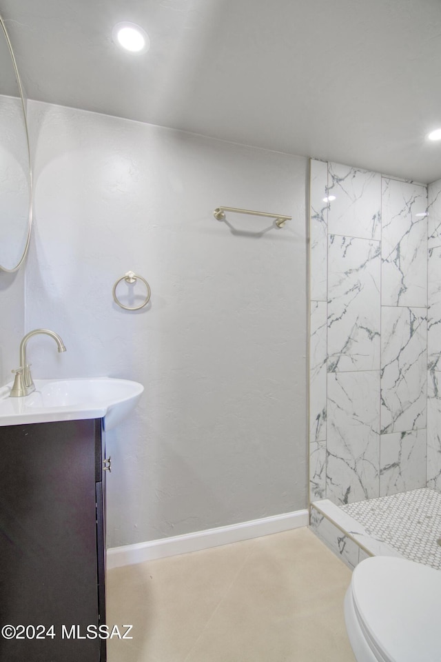 bathroom with vanity, a tile shower, recessed lighting, toilet, and baseboards