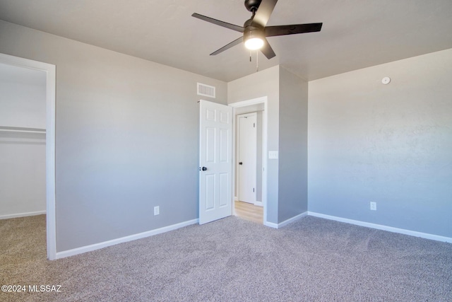unfurnished bedroom with baseboards, a ceiling fan, visible vents, and carpet