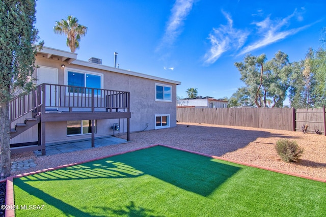 back of property with a fenced backyard, stucco siding, stairway, and a patio
