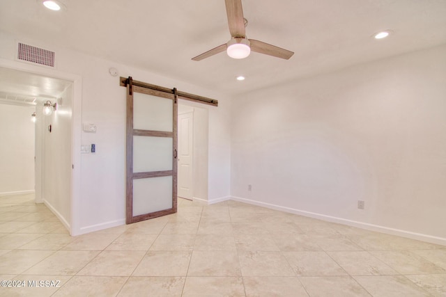 spare room featuring visible vents, recessed lighting, ceiling fan, and a barn door