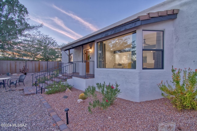 view of front of house featuring stucco siding, fence, and a patio area