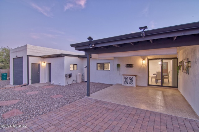 rear view of property featuring stucco siding and a patio area