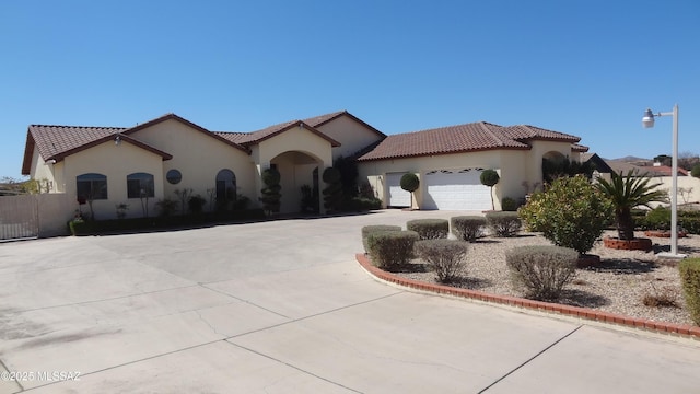 1445 W Fairway Dr, Nogales, AZ 85621 - mediterranean / spanish house with a tiled roof, stucco siding, a garage, and curved driveway