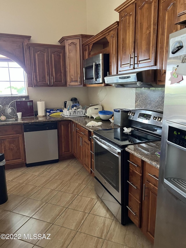 1445 W Fairway Dr, Nogales, AZ 85621 - kitchen featuring dark stone counters, under cabinet range hood, a sink, and stainless steel appliances