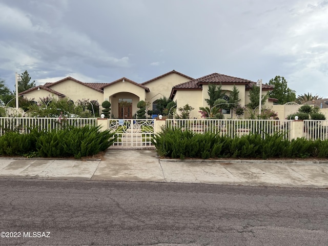 1445 W Fairway Dr, Nogales, AZ 85621 - mediterranean / spanish house featuring a fenced front yard, a tiled roof, and stucco siding