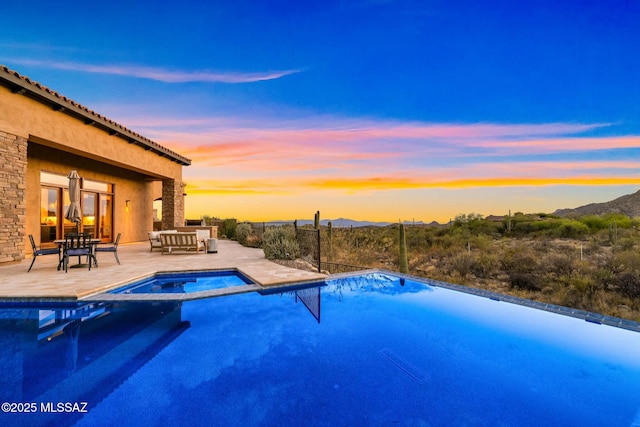 14623 N Shaded Stone Pl, Oro Valley, AZ 85755 - pool at dusk featuring a patio, a mountain view, and a pool with connected hot tub