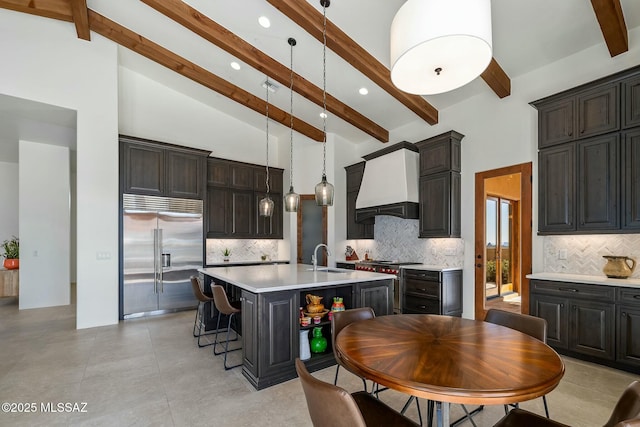 14623 N Shaded Stone Pl, Oro Valley, AZ 85755 - kitchen featuring an island with sink, a breakfast bar, light countertops, premium range hood, and high quality appliances
