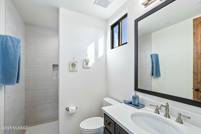 14623 N Shaded Stone Pl, Oro Valley, AZ 85755 - bathroom with vanity, visible vents, a tile shower, and toilet