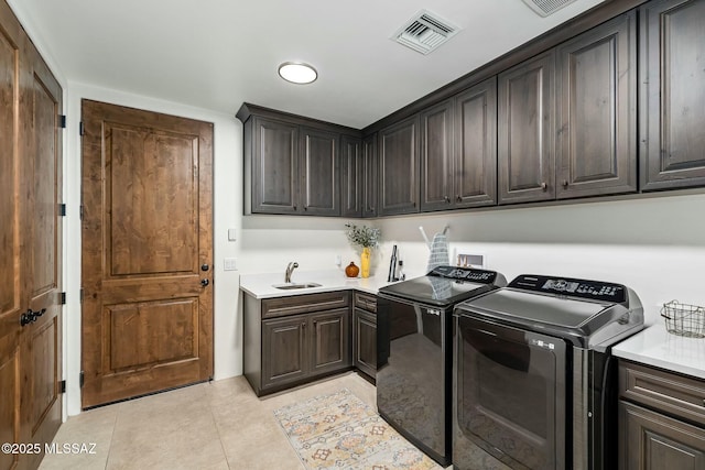 14623 N Shaded Stone Pl, Oro Valley, AZ 85755 - washroom featuring separate washer and dryer, visible vents, light tile patterned flooring, a sink, and cabinet space