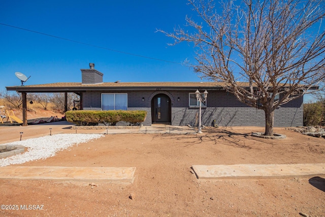 single story home featuring a chimney